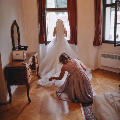 mother adjusts brides dress  Castle Hluboka wedding 