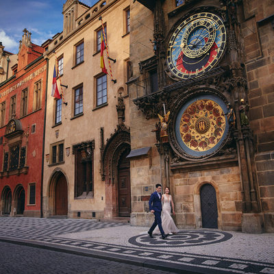 elegant couple running under the Astronomical Clock 
