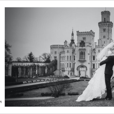 groom picks up wife for a kiss at Hluboka Castle