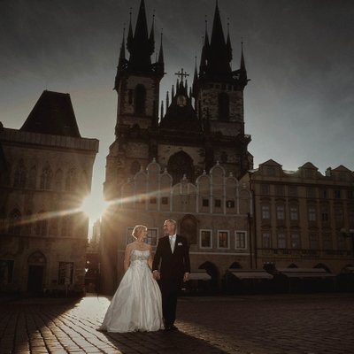 wedded couple walking in Prague's Old Town at sunrise
