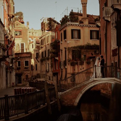 wedded couple watching sunrise over canals of Venice