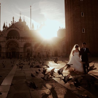 Silhouette of bride & groom walking St Mark’s Basilica