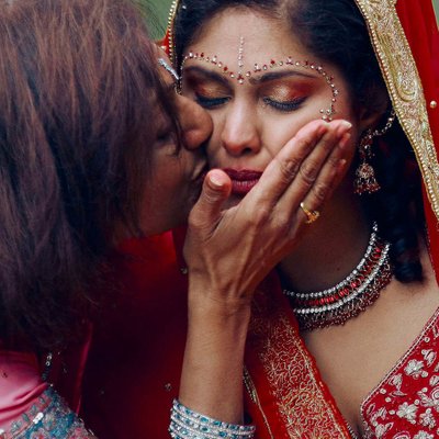 tearful Indian bride caressed by her mother