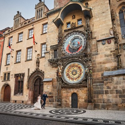 Bride & groom running under Astronomical Clock Prague