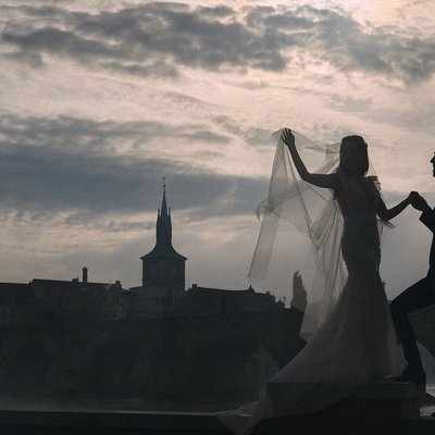 Bride & designer dress overlooking foggy Charles Bridge