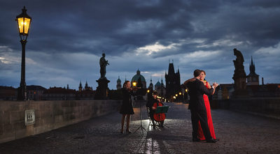woman in red dancing under gas lamps Charles Bridge
