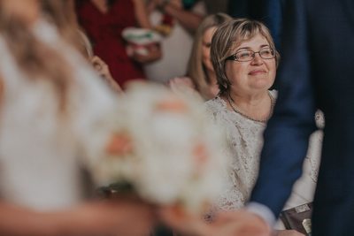 the proud mother of the groom watches her son