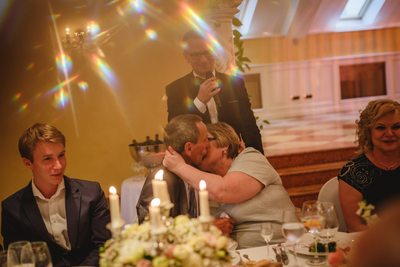 The brides parents kiss at the wedding dinner