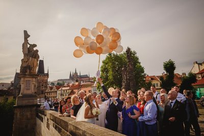 wedded couple releasing balloons on Charles Bridge