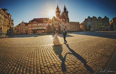 walking hand in hand at sunrise Old Town Square Prague