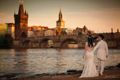 Newlyweds walking along the riverside at sunset