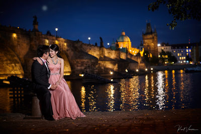 elegant lovers near Charles Bridge at night