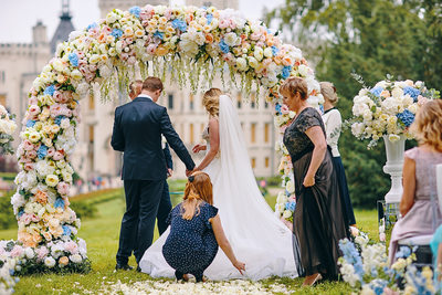 bride's sister adjusts her wedding dress