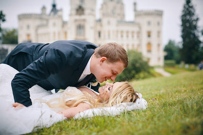 Kiss for the bride as she lies on the grass