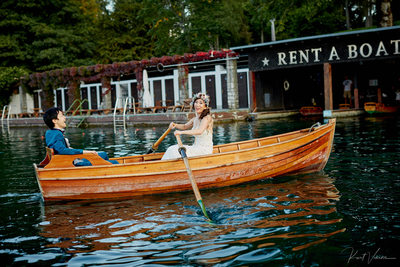 Bride rowing  the boat as groom laughs