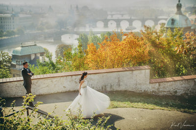 twirling Korean bride as groom watches above Prague 