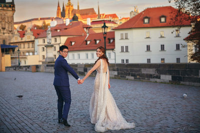 walking hand in hand across the Charles Bridge 