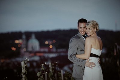 newlyweds cuddling in the vineyards overlooking Prague