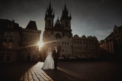 wedded couple walking in Prague's Old Town at sunrise