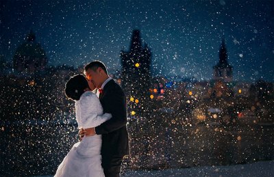 bride & groom kissing at night in a snowstorm in Prague