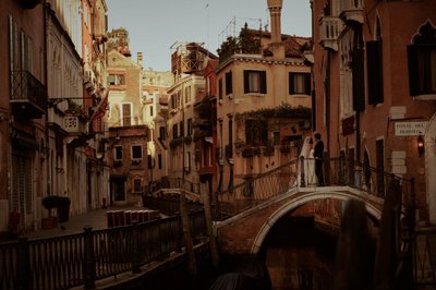 wedded couple watching sunrise over canals of Venice