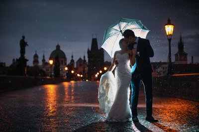 Hong Kong couple in the rain atop Charles Bridge at night