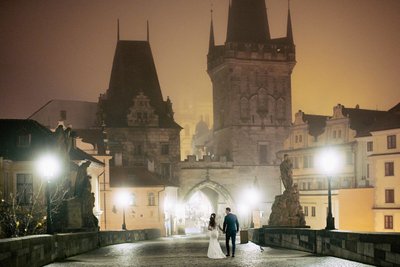 Strolling hand in hand on the foggy Charles Bridge at night