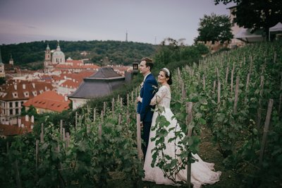 Newlyweds embrace in vineyards above Prague