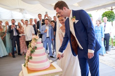 Newlyweds cut the wedding cake,a Villa Richter, Prague