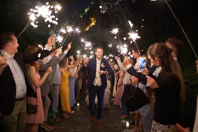 The beaming Groom is saluted with sparklers at the Villa Richter