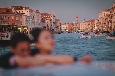 Thai couple enjoying a private boat ride in Venice at twilight