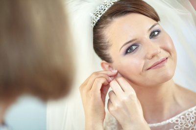 Bride putting on earring