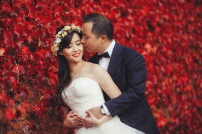 Ting & Jeff Embrace near the wall of red ivy in Prague