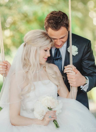 Newlyweds enjoy private moment as bride sits on swing