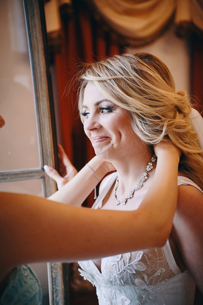 The gorgeous bride Anna as her mother puts her necklace on