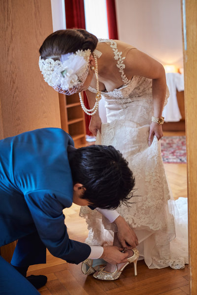 groom helps bride with shoes I Vila Bled Weddings