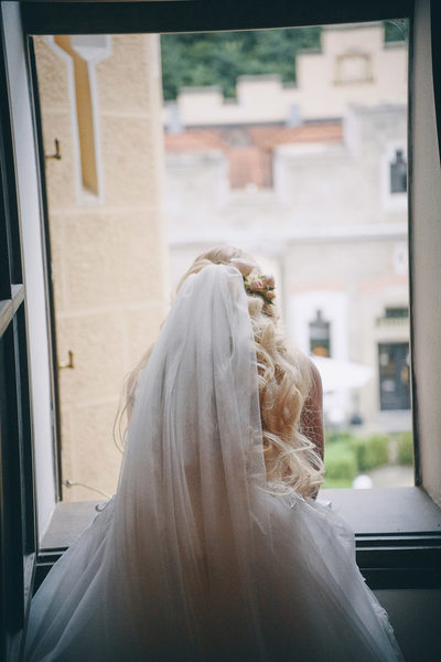 Bride peers outside of hotel window