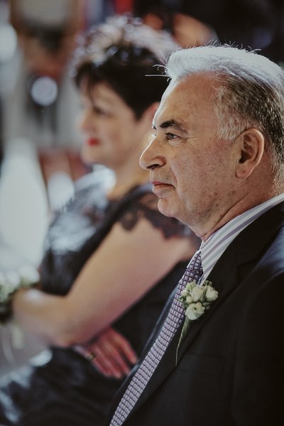 groom's father watches his son marry