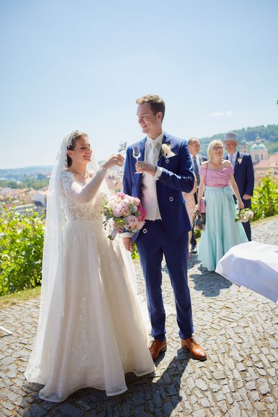 Newlyweds toast at vineyard above Prague