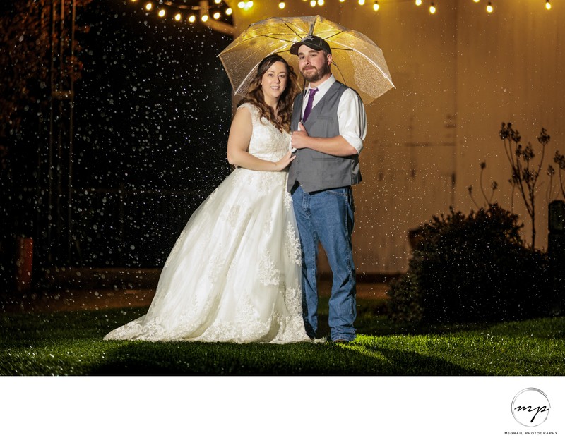Bride and Groom Under Umbrella in Rainy Night Wedding