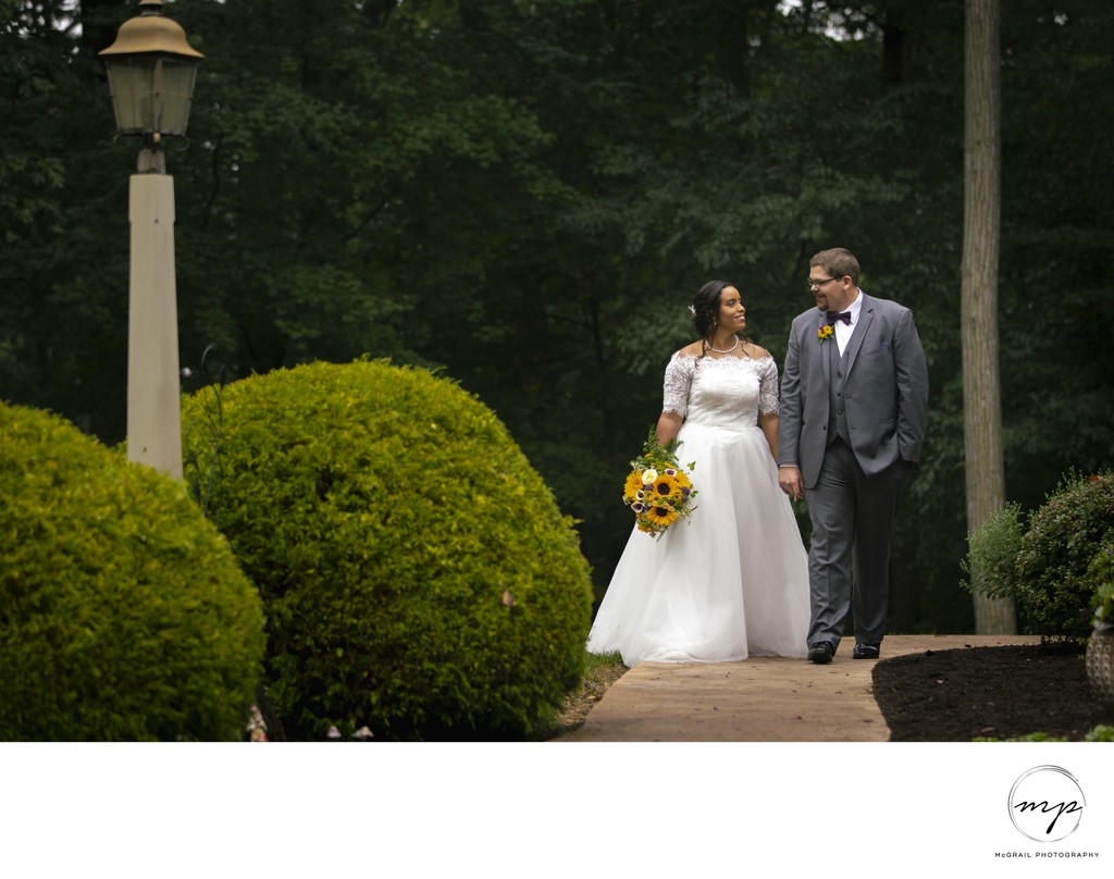 Bride and Groom Stroll Through Lush Garden