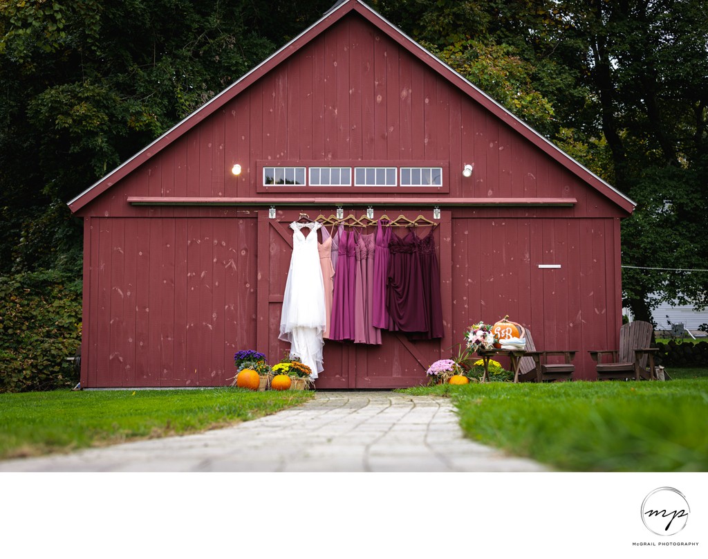 Bridal and Bridesmaids' Dresses Hanging by Rustic Barn