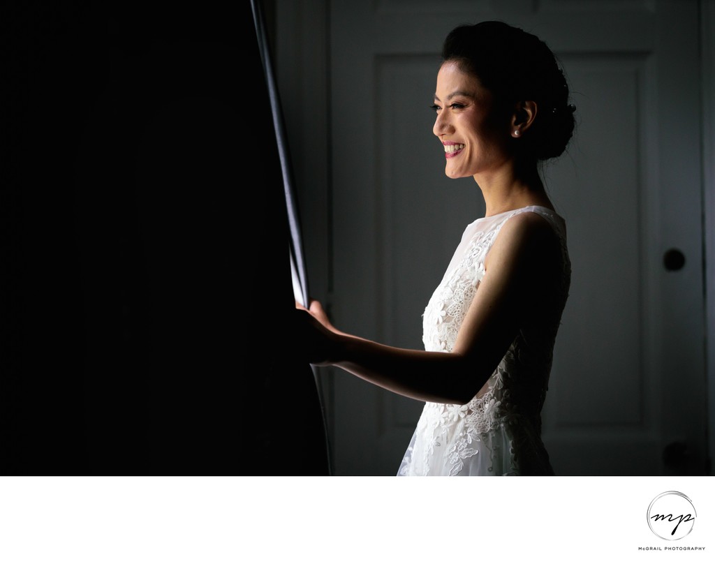 Radiant Bride Smiling by the Window in Dramatic Light 