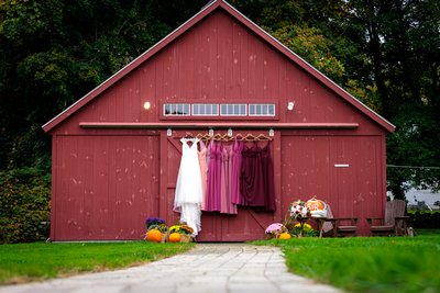 Bridal and Bridesmaids' Dresses Hanging by Rustic Barn