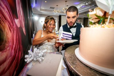 fun playful wedding photography of couple with cake