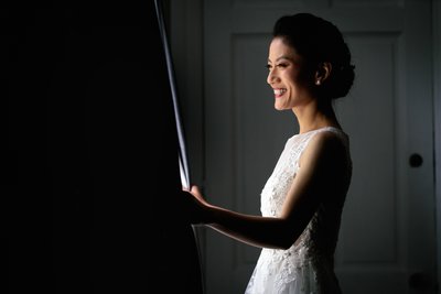 Radiant Bride Smiling by the Window in Dramatic Light 