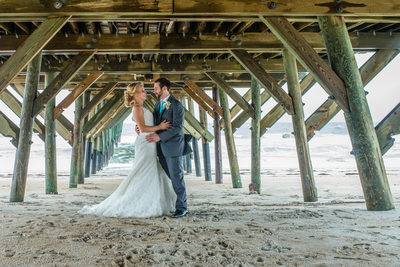 Groom and Bride under the pier at Wrightsville Beach