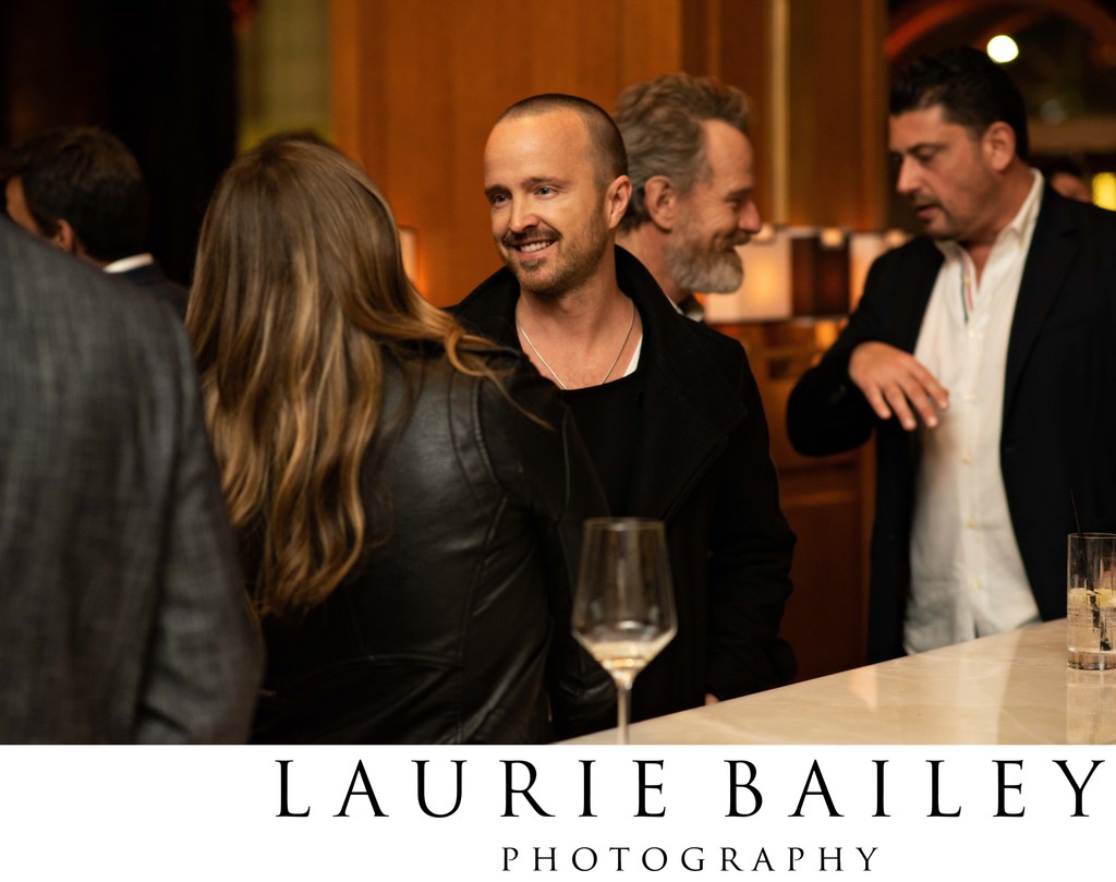 Aaron Paul shares a candid moment near the bar at the event