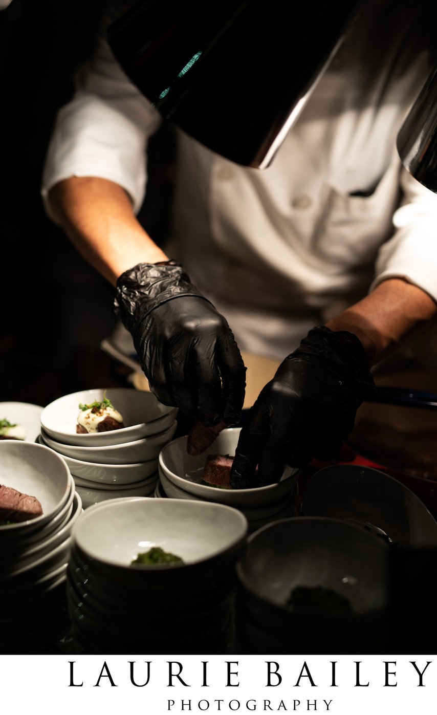 A chef prepares small plates during dinner service