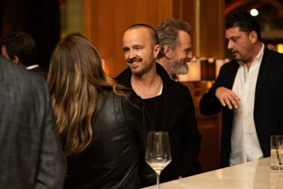 Aaron Paul shares a candid moment near the bar at the event